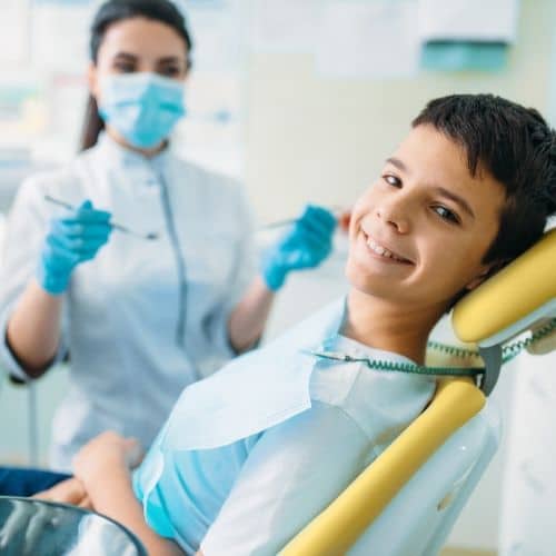 niño tratandose las caries en la clínica