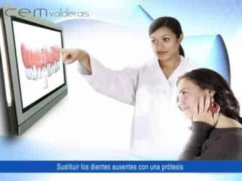 
dentista explicando al paciente que poner implantes dentales duele